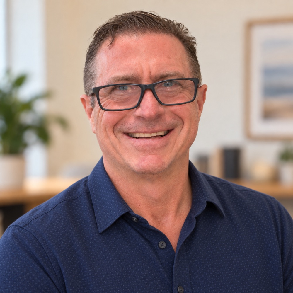 Perry Gordon, founder of Sites In One Day, wearing glasses and a blue collared shirt.
